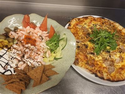 Pizza and a plate with shrimps. 