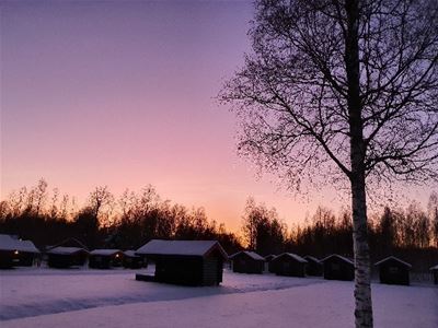 Sunset over the cottages in a winter evening. 