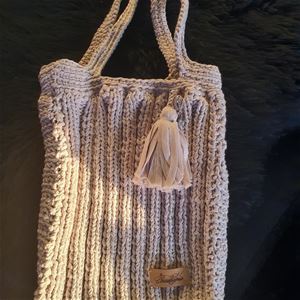 Knitted bag with a tassel on. 