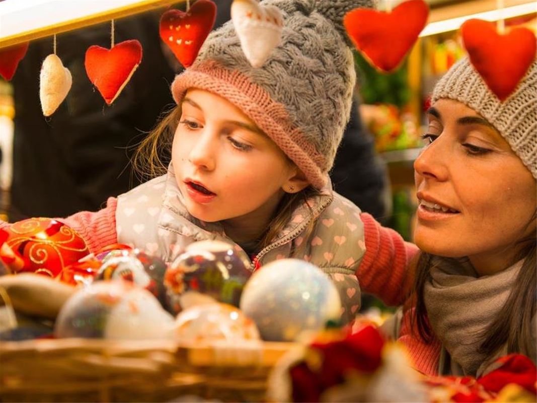 Mor och dotter tittar på julgranskulor.