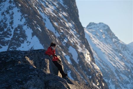 person enjoying the view of snow covered mountains