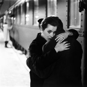 Lennart Nilsson,  © Lennart Nilsson Photography, En man och en kvinna omfamnar varandra framför ett tåg på en tågperrong.
