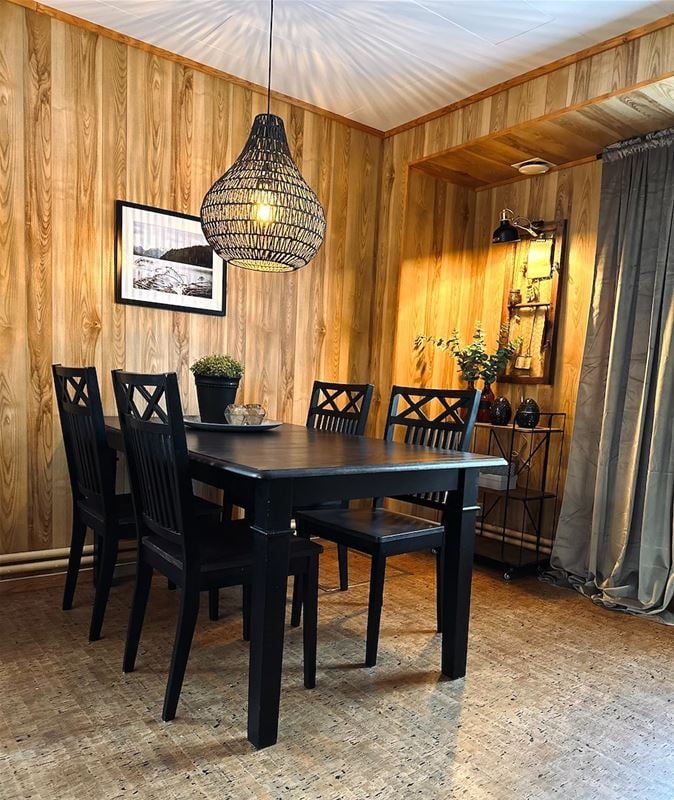 Dining table with four chairs in a wooden room. 