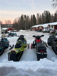 Flertalet skotrar parkerade utanför Hotellet vid Fjället. 