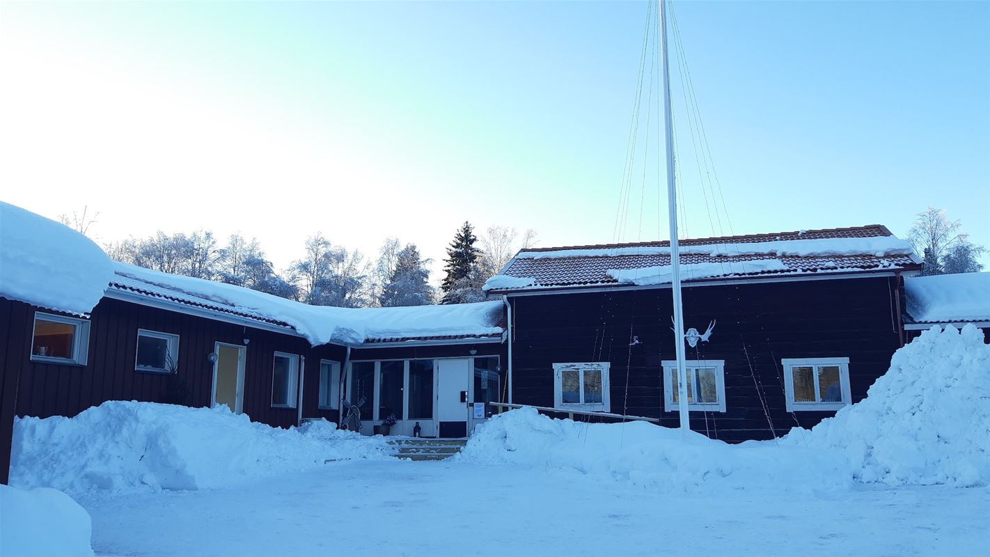 Red building with lots of snow around. 