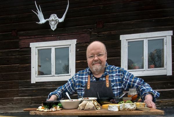 Kalle Moraeus holding a tray with various cheeses.  