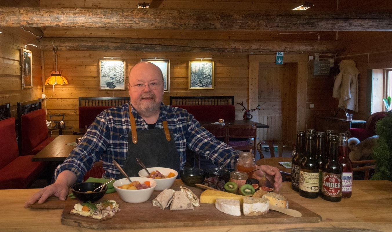 Kalle Moraeus presenterar en bricka med olika ostar och tillbehör. 