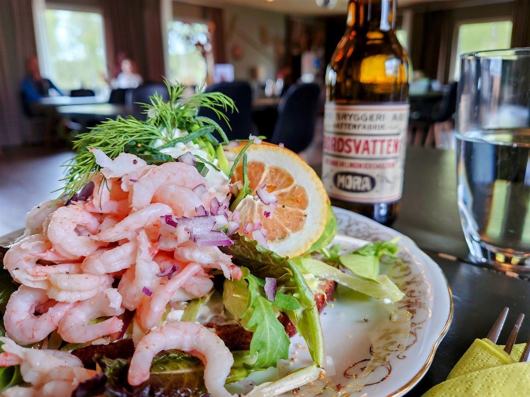 A shrimp sandwich and a glass of water. 