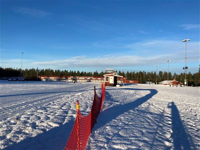 Ski track at ski stadium with fence in foreground.