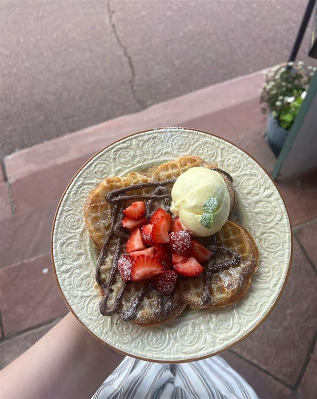 A nutella waffle with icecream on a white plate. 