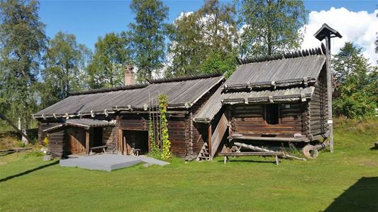 Ett timrat hus på Rots Skans i sommartid.