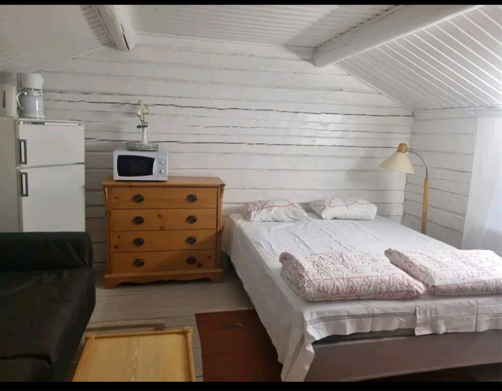 Double bed and a chest of drawers with microwave  and a fridge with a small freezer. 