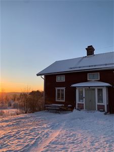 Rött hus med gröna dörrar.