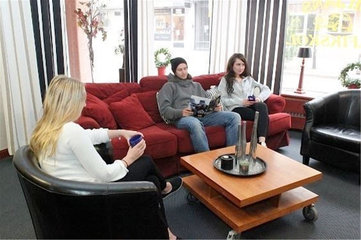 Persons in a sofa group with a cup of coffee in their hands. 