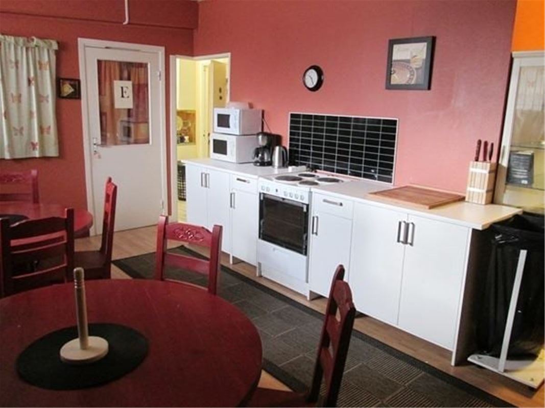Kitchen with stove, oven, microwave and dining tables. 