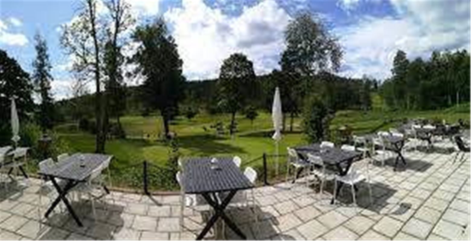 Bild på trädgården på Samuelsdals Pensionat med utsikt över golfbanan.