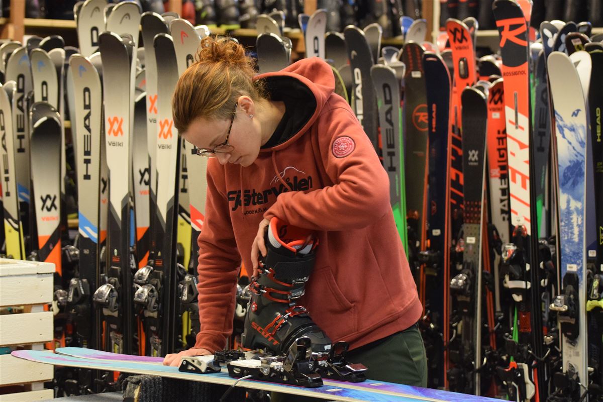 En tjej som testar en pjäxa på en slalomskida.