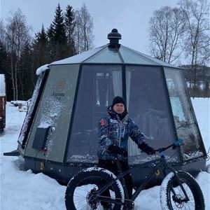 North Experience,  © North Experience, A man with a fatbike outside one of the glass iglos at North Experience