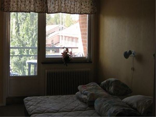 Sovrum med två enkelsängar och balkong. 