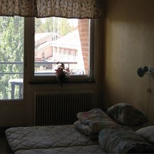 Sovrum med två enkelsängar och balkong.