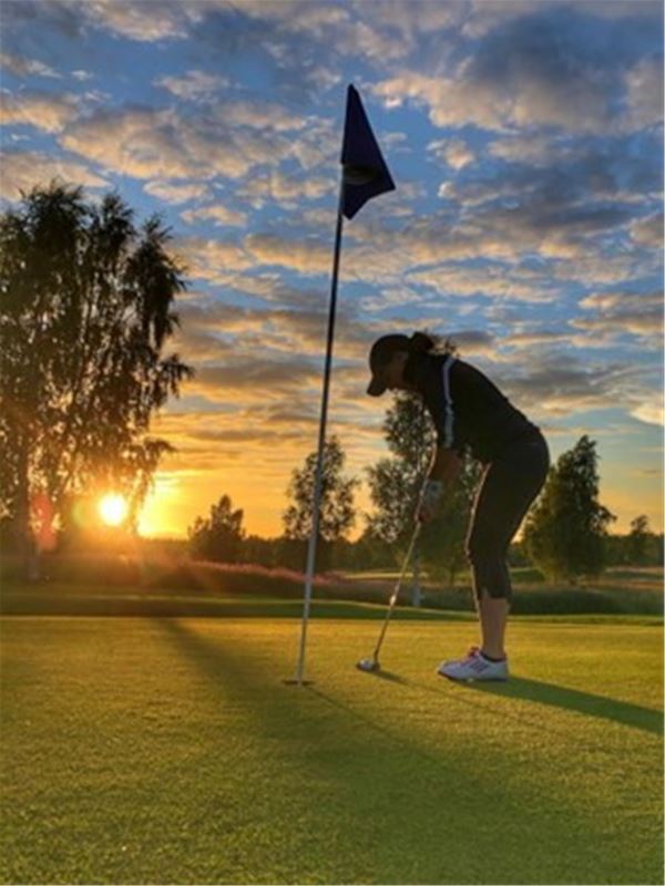 Golfspelare i solnedgång. 