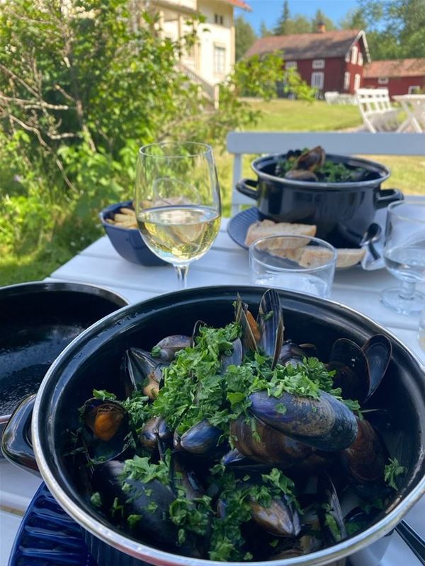Skål med musslor och ett glas vin. 