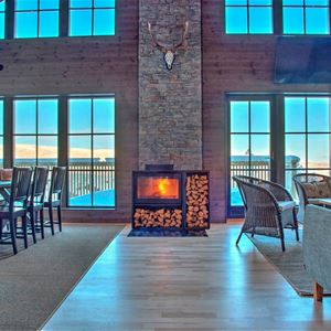 Large room with open fire place and large windows. 