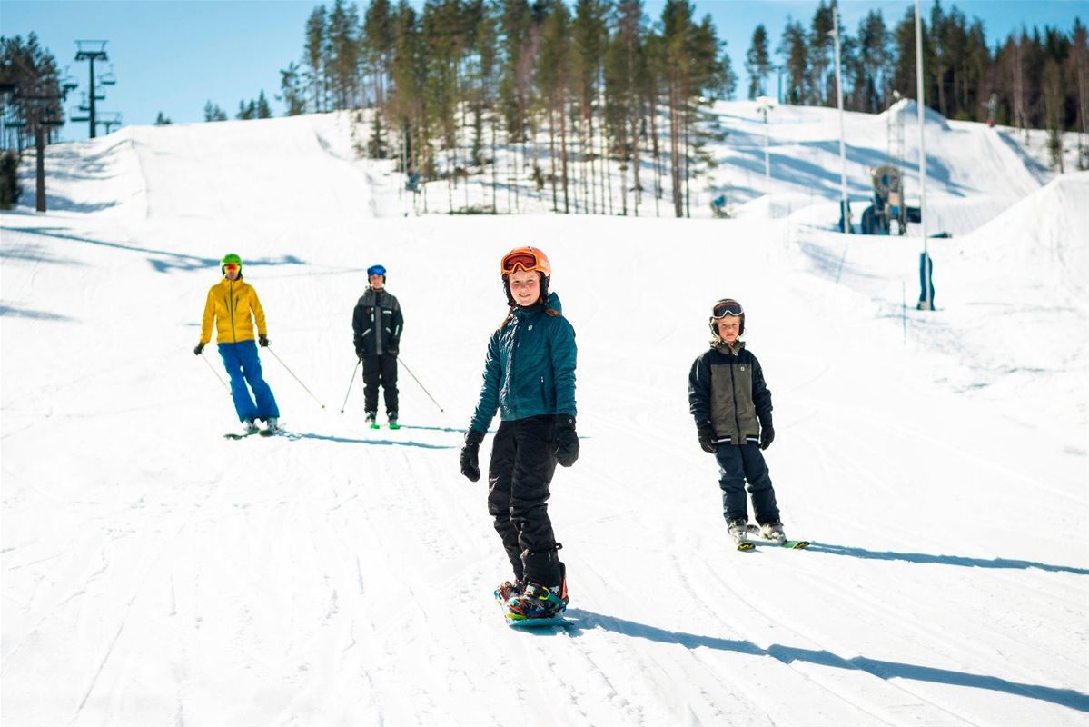 Personer som åker skidor i pisten. 