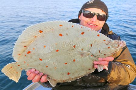 Man holding a fish on a fishing trip with Explore the Arctic