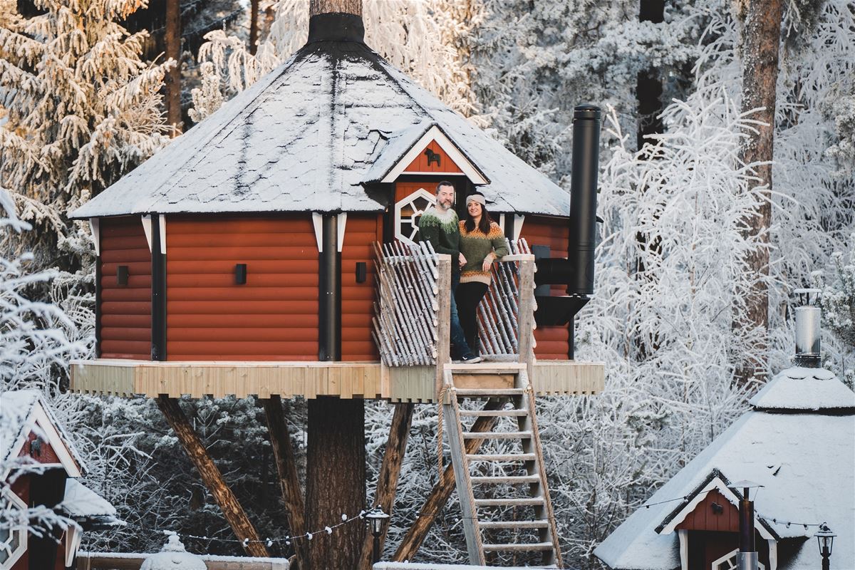 A couple in front of the treehouse. 