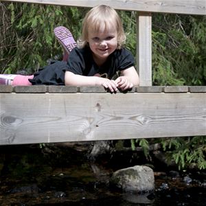 Children lying on a wooden bridge.