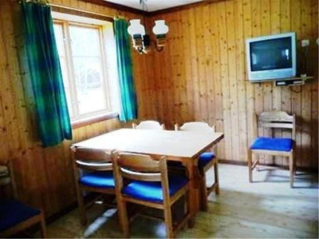 Dining table and four chairs and a television.