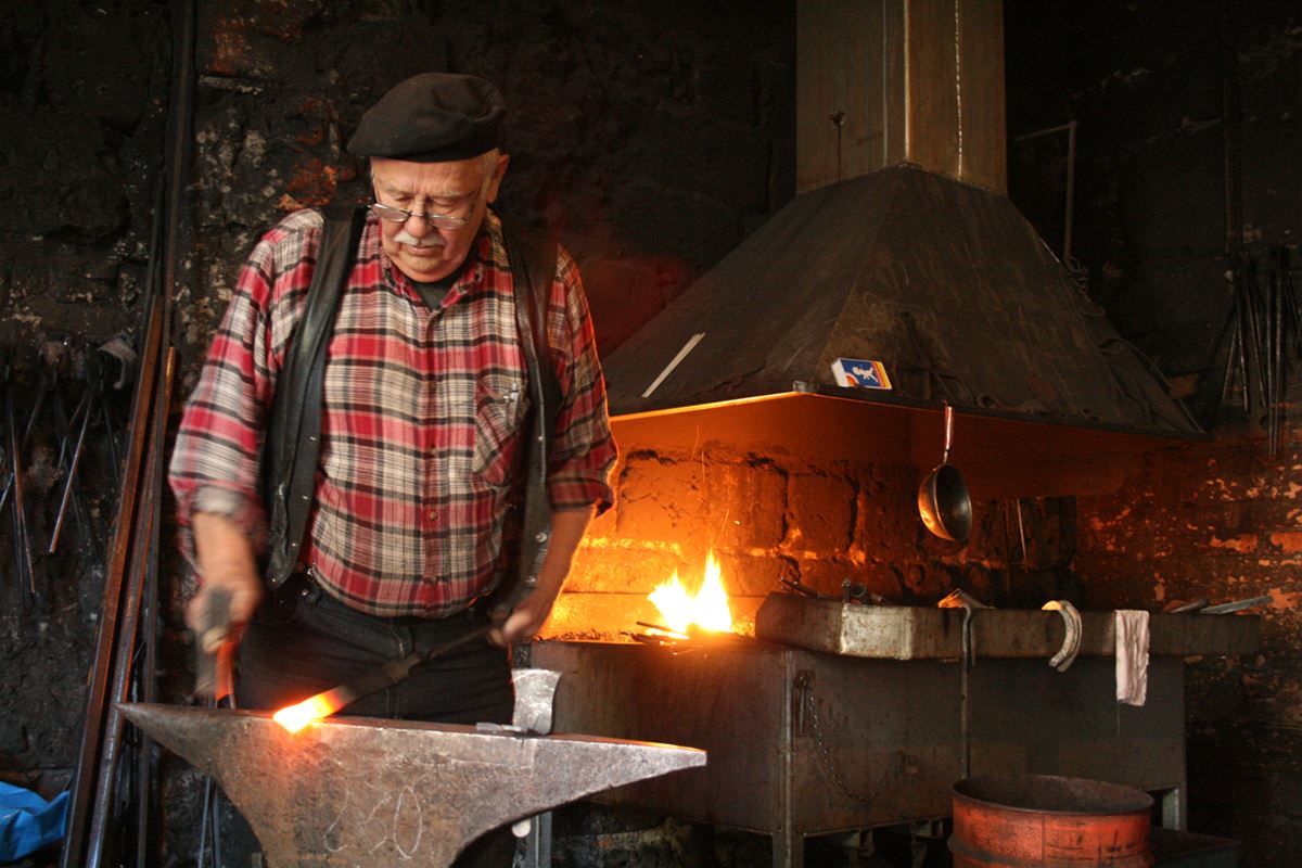 A man forging in the smithy.