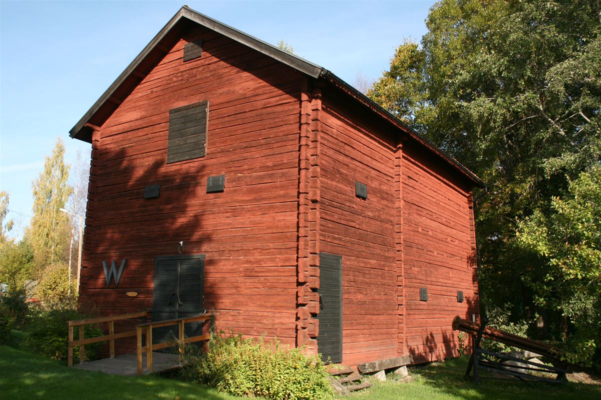 A red log house with black doors.
