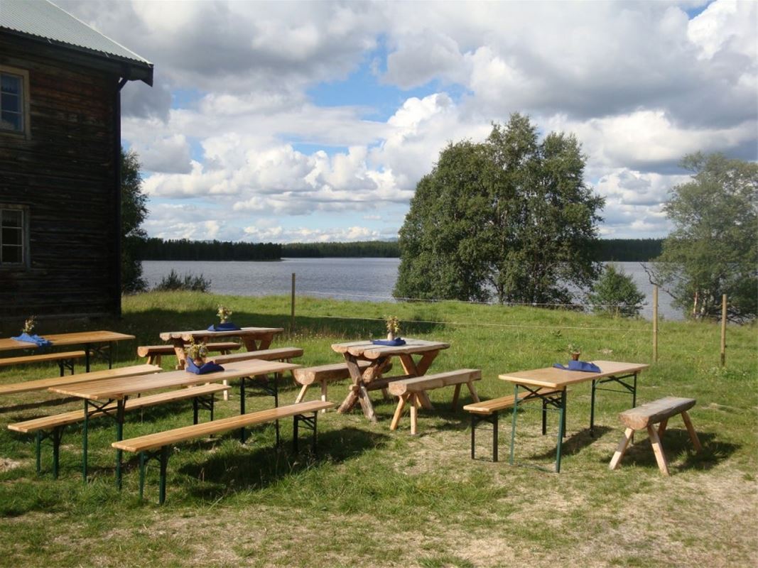 Bänkar och bord med sjö i bakgrunden