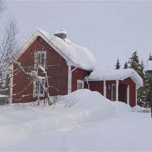 Ett av husen på gården täckt av snö.
