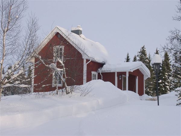 Ett av husen på gården täckt av snö. 