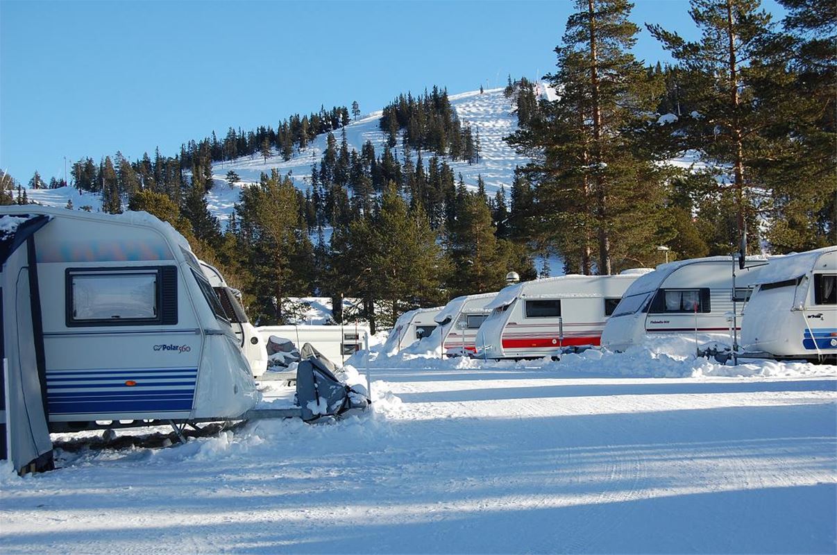 Several caravans lined up on camping in winter.