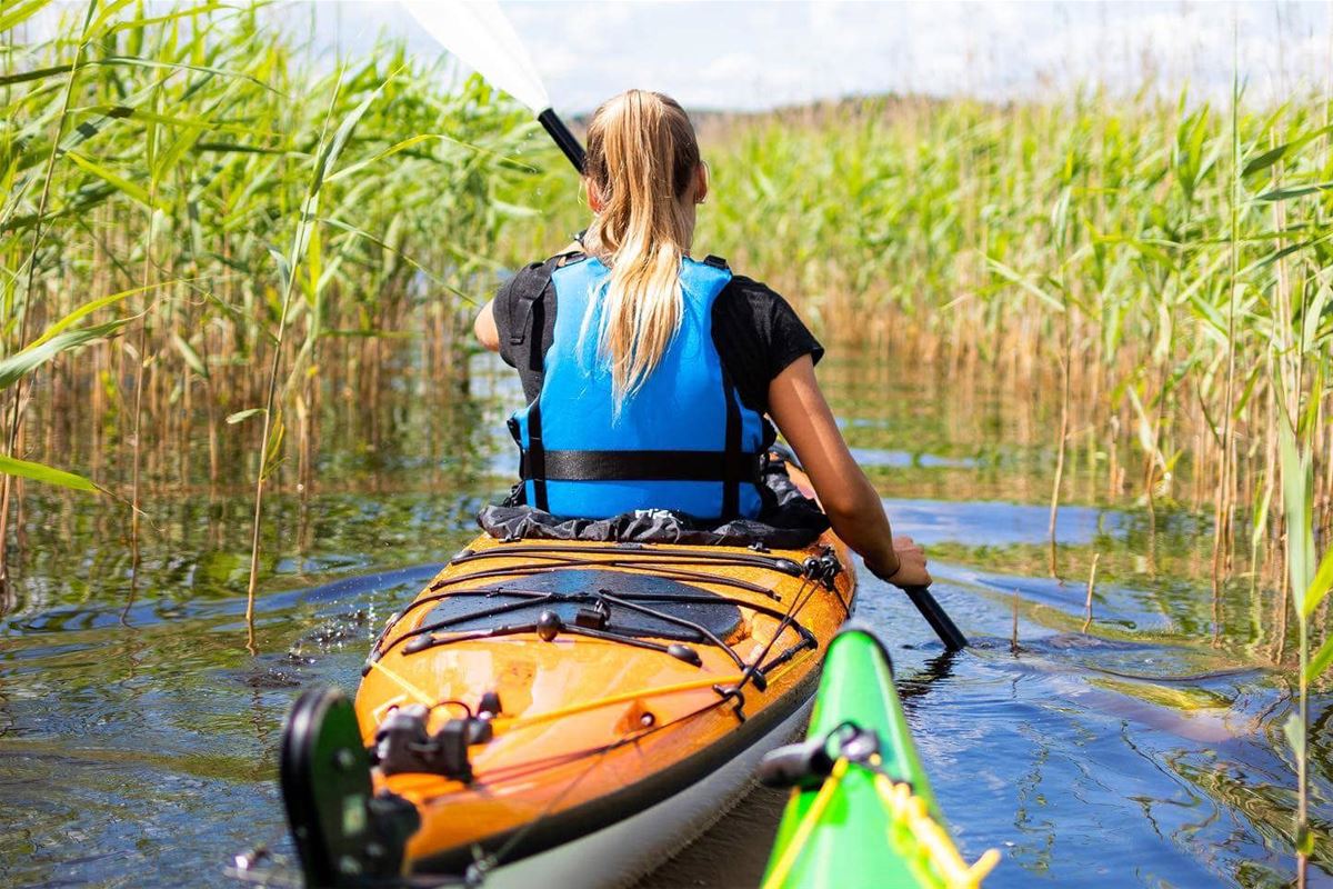 A woman paddling a kayak.