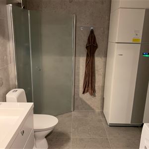 Ett badrum med en brun handduk på en krok.