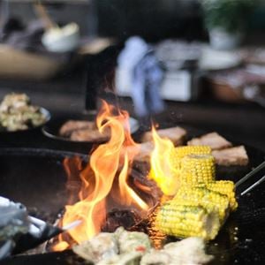 Corn on the cob cooking over a fire.