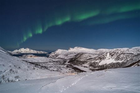 Nordlys over arktisk vinterlandskap i Tromsøregionen