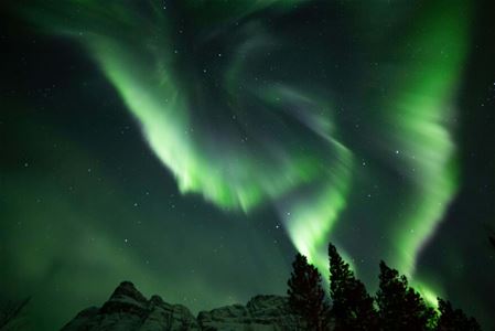 Nordlys over fjell og skog i Tromsøregionen