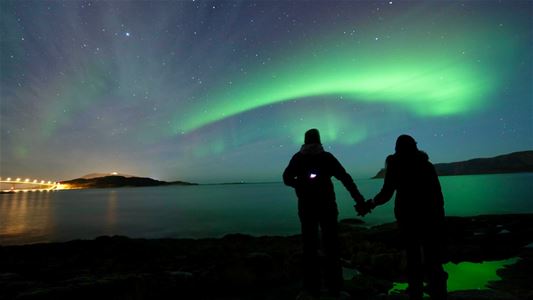 To gjester som ser på nordlyset