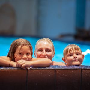 A person and two children in a pool.