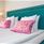 A bed with pink pillows and a blue headboard.