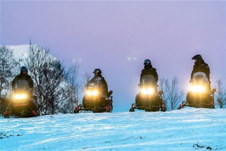 4 snow scooters face the camera at Camp Tamok