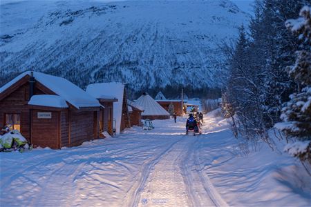 Snow scooters driving by the camp at Camp Tamok, Norway