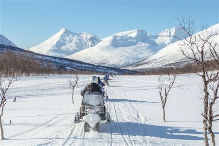 Snowmobiling in Arctic winter landscape in the Tromso
