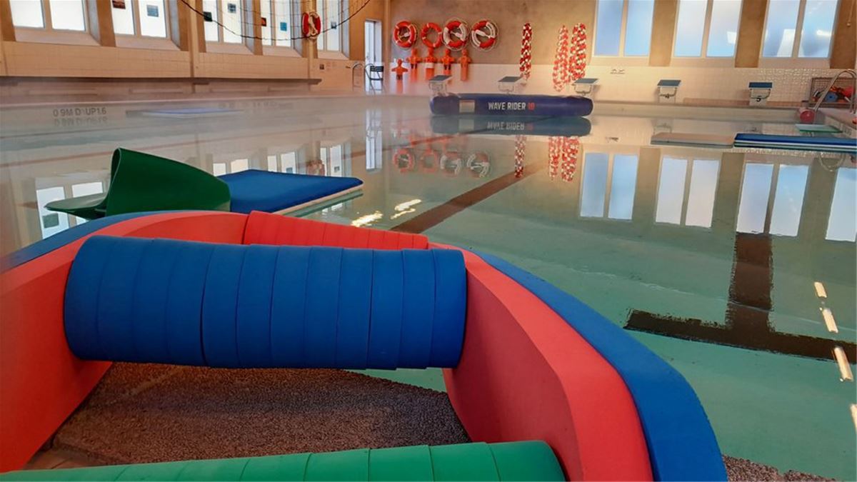 Färgbild - inomhus simbassäng i ett badhus.